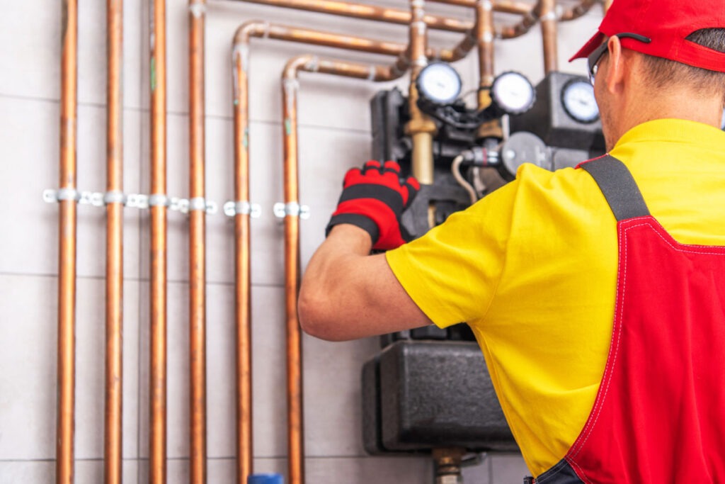 HVAC technician performing seasonal AC maintenance and inspecting mechanical components
