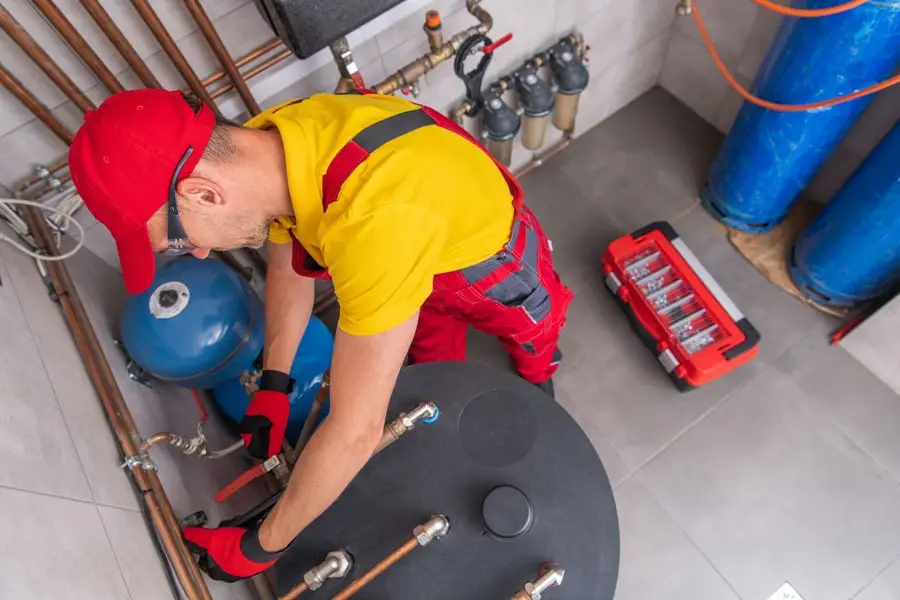 Technician servicing boiler and tank equipment for NES commercial services
