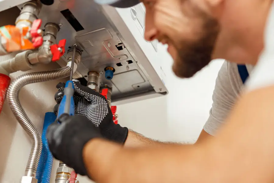 Professional technician completing final unit adjustments for a home furnace replacement