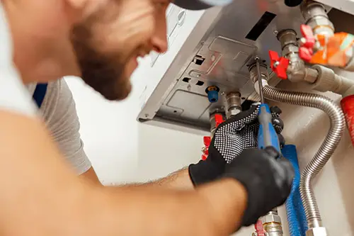 Technician repairing water heater lines featured on the NES Plumbing and HVAC blog